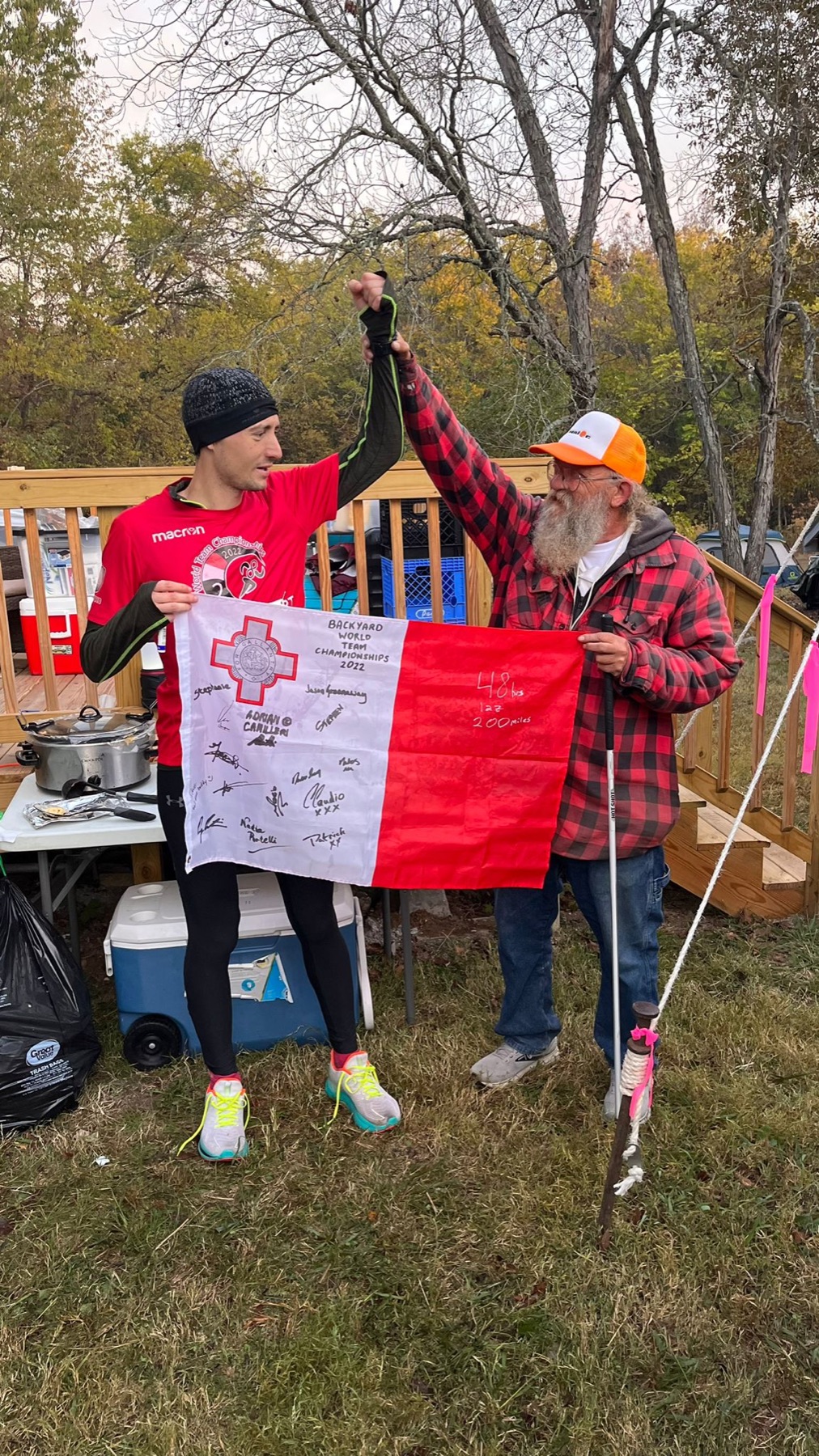 A Backyard Ultra runner celebrating with the championship flag at Big's Backyard Ultra